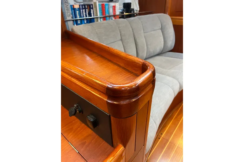 Slide: The Image of Interior of 1999 Oyster 53 Deck Saloon with wooden finish and gray seating. - 35