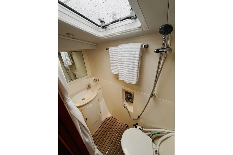 Slide: The Image of Compact bathroom in 1999 Oyster 53 Deck Saloon yacht with shower, sink, and towel rack. - 6