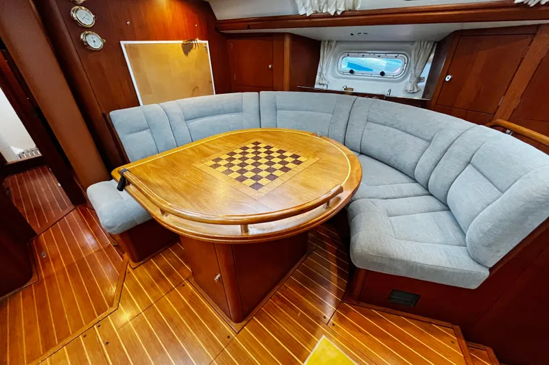 Slide: The Image of Luxurious 1999 Oyster 53 Deck Saloon interior with elegant wood and plush seating. - 14