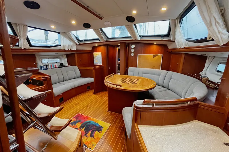 Slide: The Image of Luxurious 1999 Oyster 53 Deck Saloon interior with elegant wood finish and plush seating. - 12