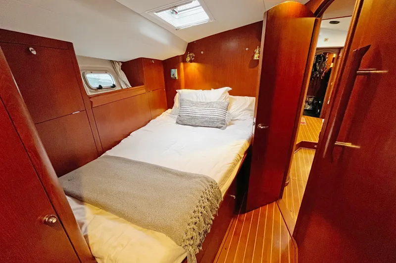 Slide: The Image of Cozy bedroom in 1999 Oyster 53 Deck Saloon yacht with wooden interior and skylight. - 2