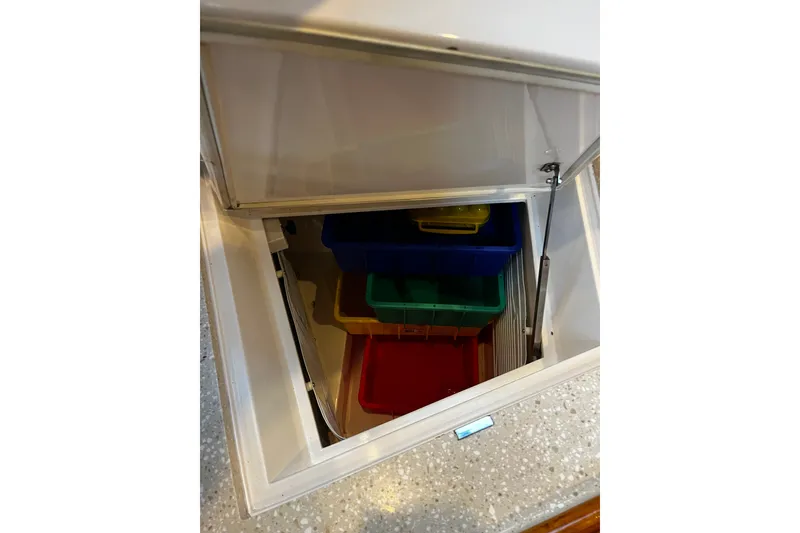 Slide: The Image of Storage compartment with colorful bins inside a 1999 Oyster 53 Deck Saloon yacht. - 45