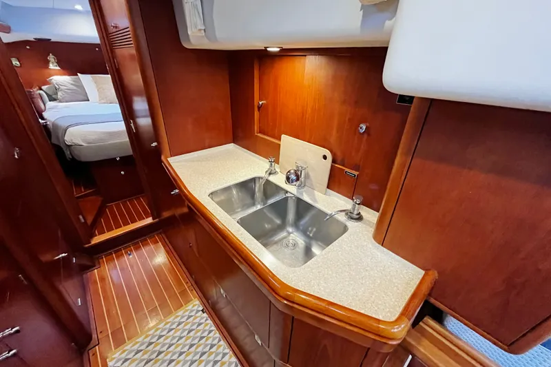 Slide: The Image of Luxurious galley in 1999 Oyster 53 Deck Saloon yacht with wooden cabinetry and double sink. - 24