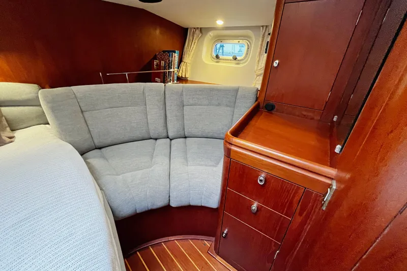 Slide: The Image of Luxurious interior of a 1999 Oyster 53 Deck Saloon with plush seating and wooden cabinetry. - 28