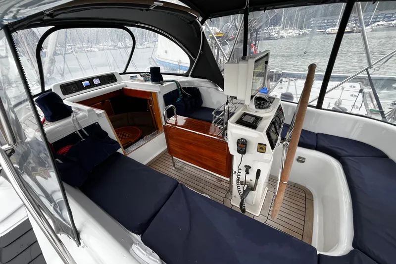 Slide: The Image of Interior view of a 1999 Oyster 53 Deck Saloon yacht with navigation equipment and seating. - 71