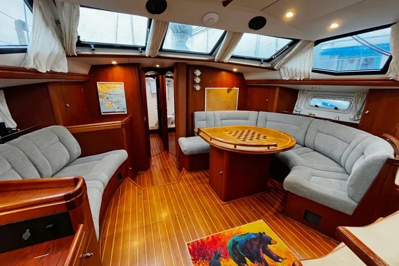 Slide: The Image of Luxurious 1999 Oyster 53 Deck Saloon interior with elegant wood finish and plush seating. - 13