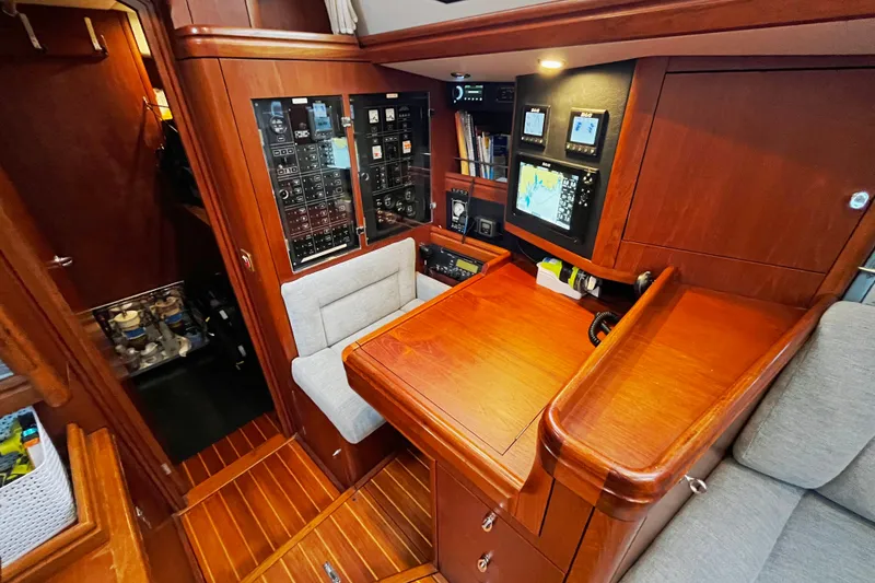 Slide: The Image of Navigation station of a 1999 Oyster 53 Deck Saloon yacht with control panels and seating. - 19
