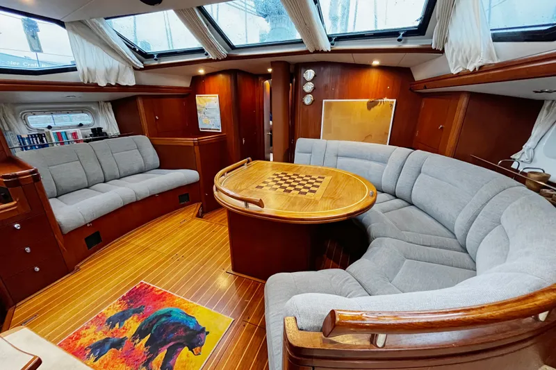 Slide: The Image of Luxurious 1999 Oyster 53 Deck Saloon interior with elegant wood finish and plush seating. - 1