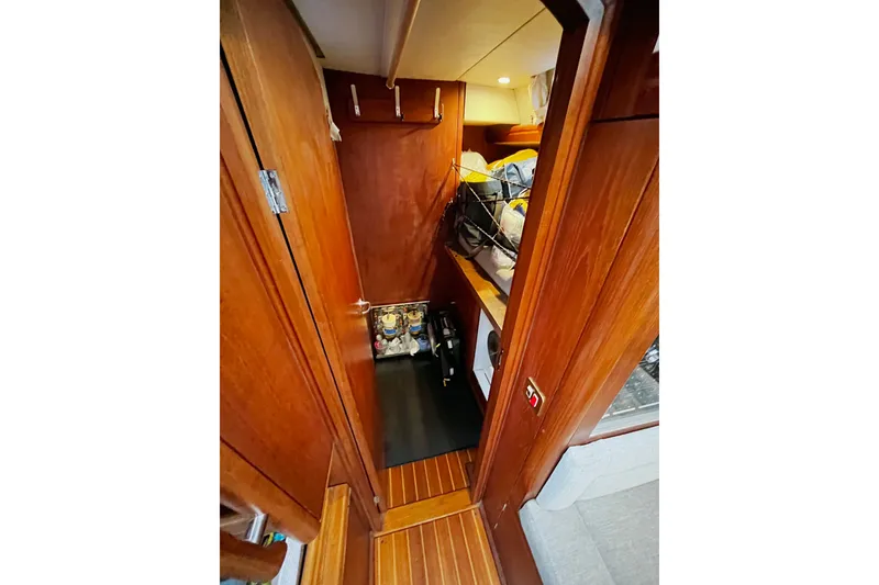 Slide: The Image of Interior of 1999 Oyster 53 Deck Saloon with wooden cabinetry and storage space. - 21