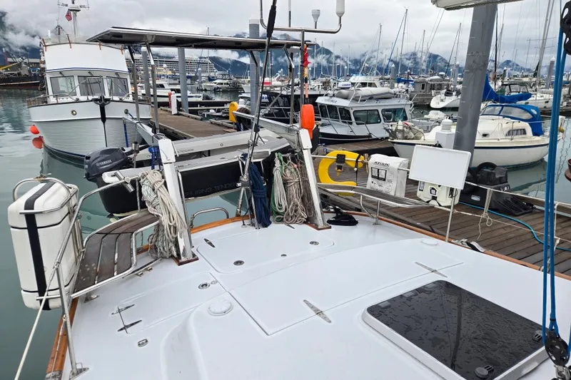Slide: The Image of 1999 Oyster 53 Deck Saloon yacht docked in a bustling marina with surrounding boats. - 68