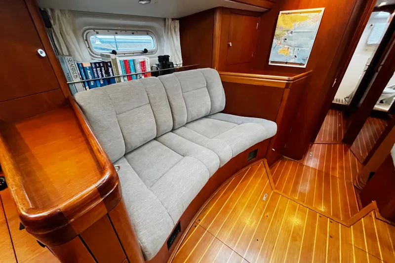 Slide: The Image of Luxurious interior of 1999 Oyster 53 Deck Saloon with plush seating and wooden finishes. - 16