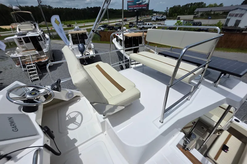 Slide: The Image of Flybridge of 2026 Ranger Tugs R-29 CB with seating and steering wheel, docked outdoors. - 4