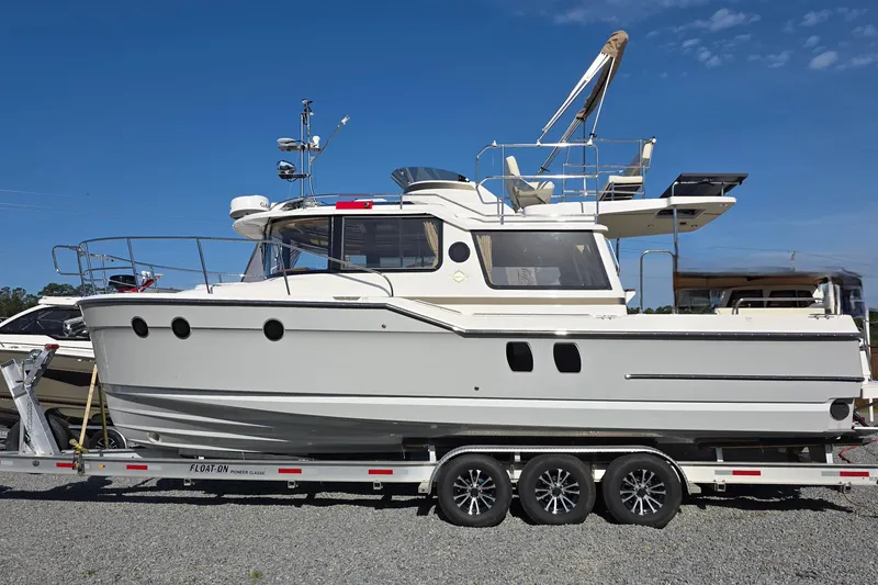 The Image of 2026 Ranger Tugs R-29 CB boat on trailer under clear blue sky. - 1