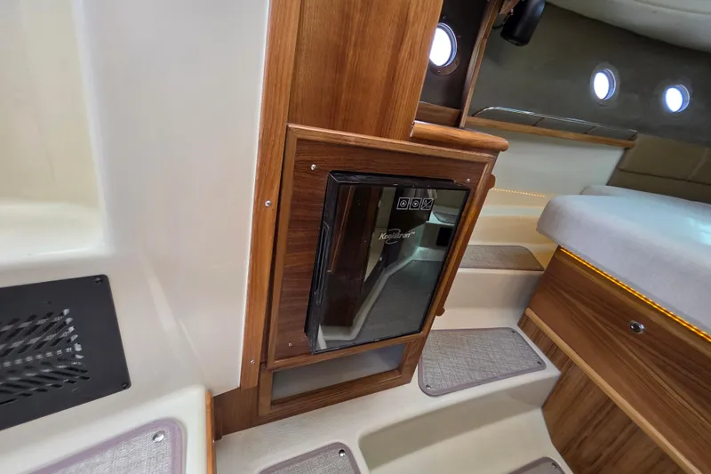 Slide: The Image of 2026 Ranger Tugs R-29 CB cabin interior with wooden accents and compact fridge. - 9