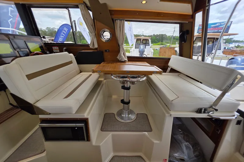 Slide: The Image of Interior of 2026 Ranger Tugs R-29 CB with seating and table, showcasing modern design. - 7