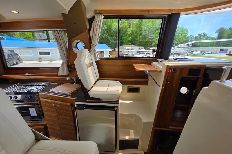 Slide: The Image of Interior of 2026 Ranger Tugs R-29 CB, featuring helm station and galley with modern amenities. - 8