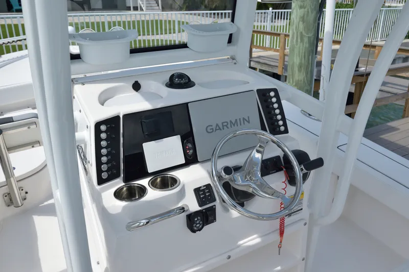 Slide: The Image of 2023 Robalo 246 Cayman boat dashboard with Garmin navigation system and steering wheel. - 22