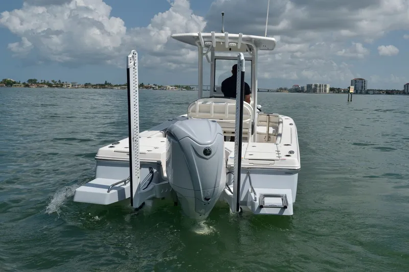 Slide: The Image of A 2023 Robalo 246 Cayman boat on calm water. It features an outboard motor and a T-top. - 3