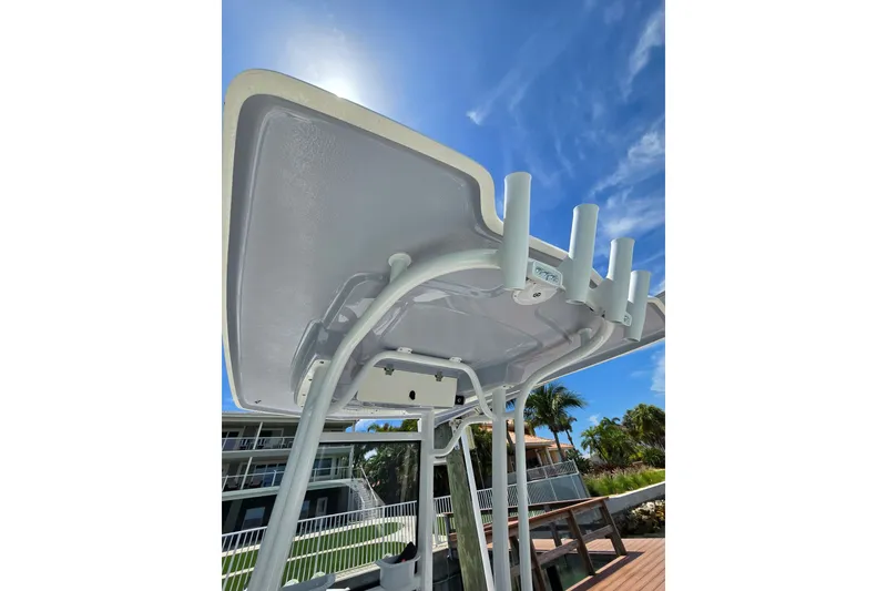 Slide: The Image of 2023 Robalo 246 Cayman boat T-top with rod holders under clear blue sky. - 42