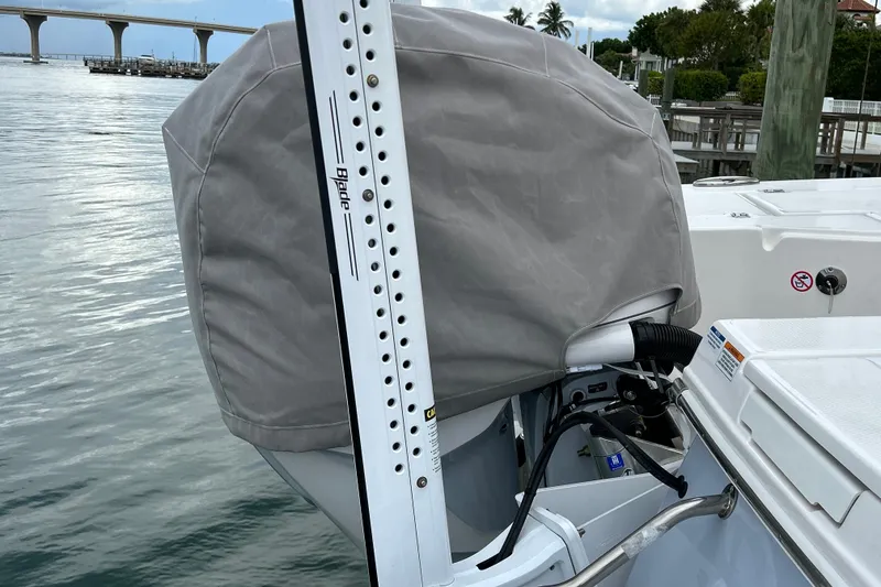 Slide: The Image of 2023 Robalo 246 Cayman boat with covered engine and power pole, docked near a bridge. - 41