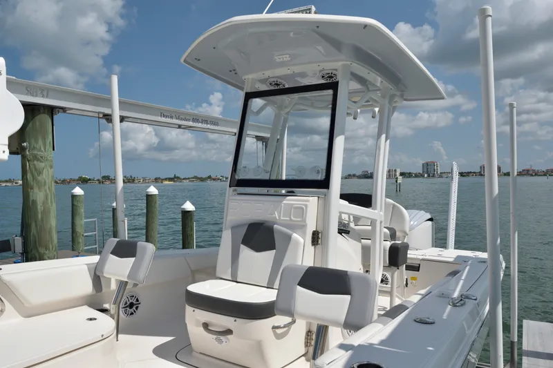 Slide: The Image of 2023 Robalo 246 Cayman boat docked by the water, showcasing sleek design and seating. - 25