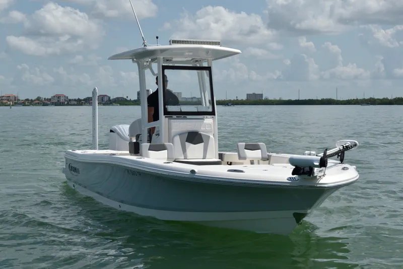 Slide: The Image of A white 2023 Robalo 246 Cayman boat on calm water under a cloudy sky. - 5