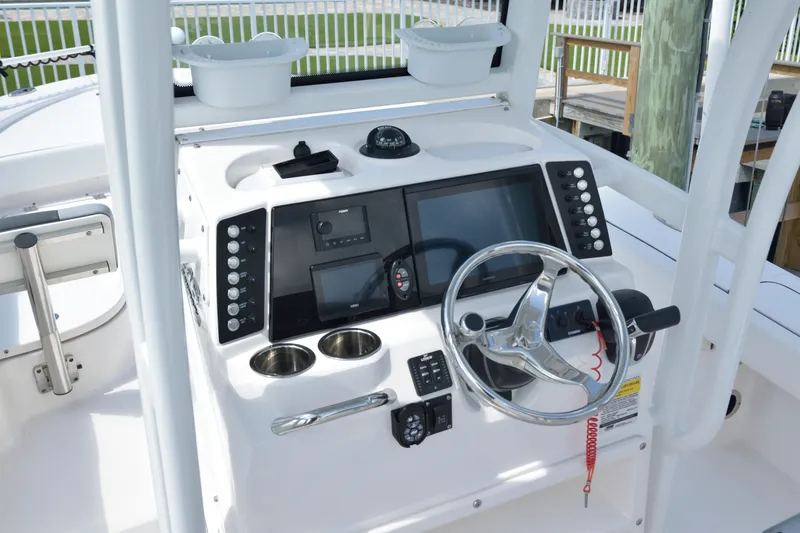 Slide: The Image of 2023 Robalo 246 Cayman boat dashboard with steering wheel and navigation controls. - 21