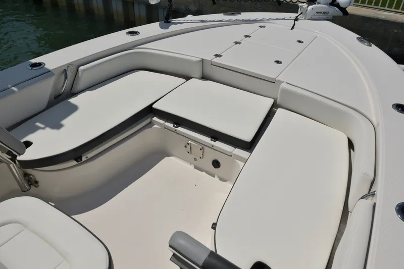 Slide: The Image of 2023 Robalo 246 Cayman boat interior with cushioned seating and storage compartments. - 32