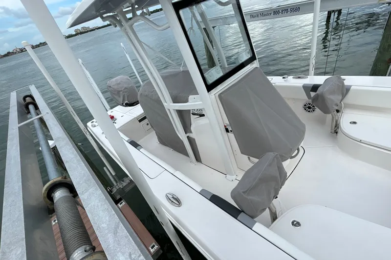 Slide: The Image of 2023 Robalo 246 Cayman boat docked, featuring covered seats and a sleek design. - 46