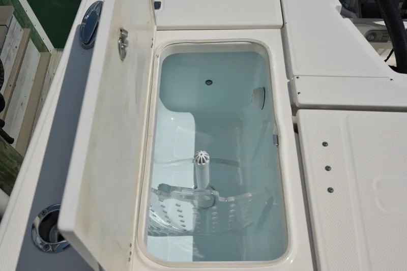 Slide: The Image of Livewell compartment on a 2023 Robalo 246 Cayman boat, open and empty. - 12