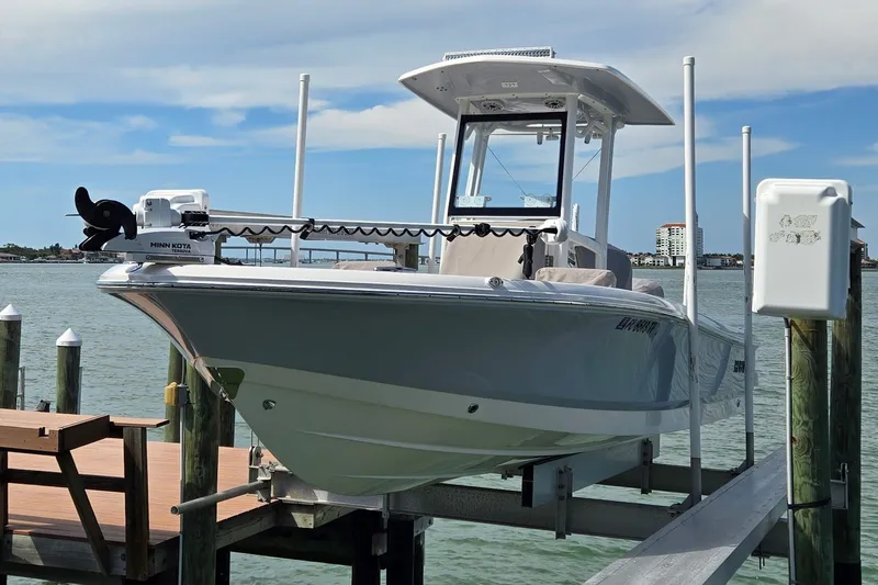 Slide: The Image of 2023 Robalo 246 Cayman boat docked on lift, featuring Minn Kota motor. - 6