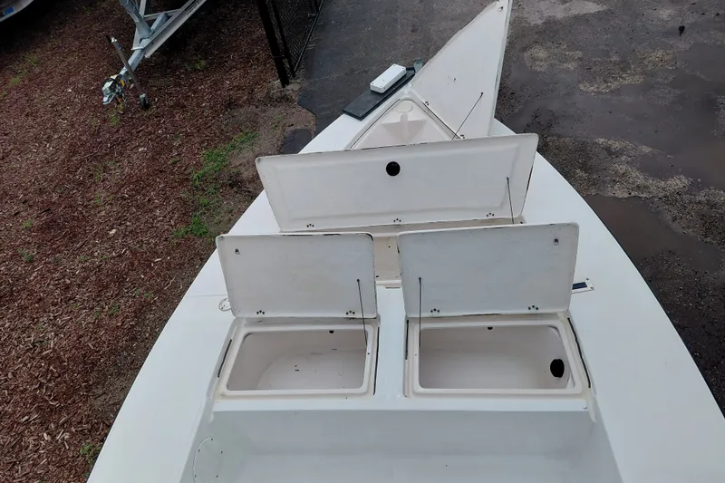 Slide: The Image of Open storage compartments on a 2000 Eagle 21 boat, parked on a gravel surface. - 28