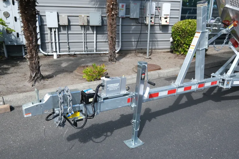 Slide: The Image of Trailer hitch of a 2026 Hewescraft 250 Pacific Explorer with safety chains and hydraulic brake. - 23
