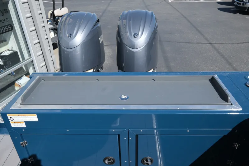 Slide: The Image of 2026 Hewescraft 250 Pacific Explorer with dual outboard motors, blue deck view. - 20