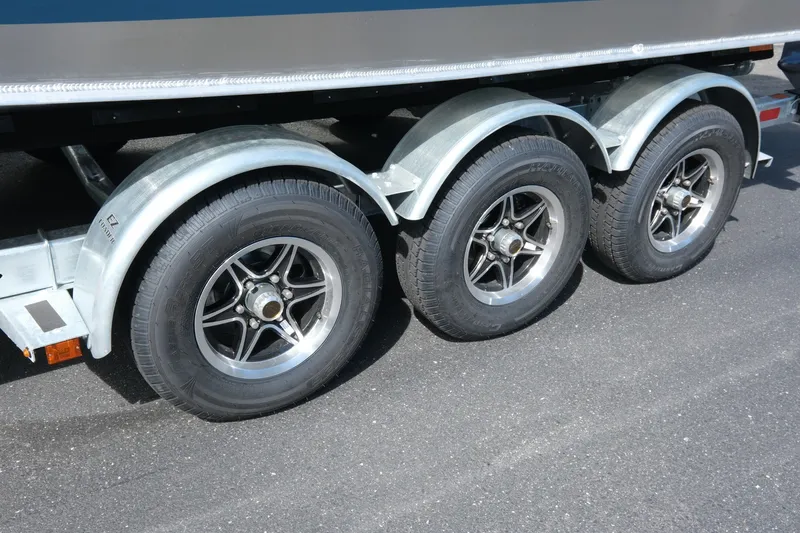 Slide: The Image of Triple-axle trailer for 2026 Hewescraft 250 Pacific Explorer on asphalt. - 24