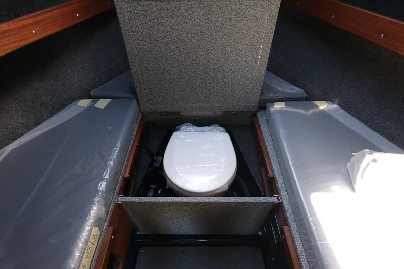Slide: The Image of 2026 Hewescraft 250 Pacific Explorer cabin interior with compact toilet and seating. - 17