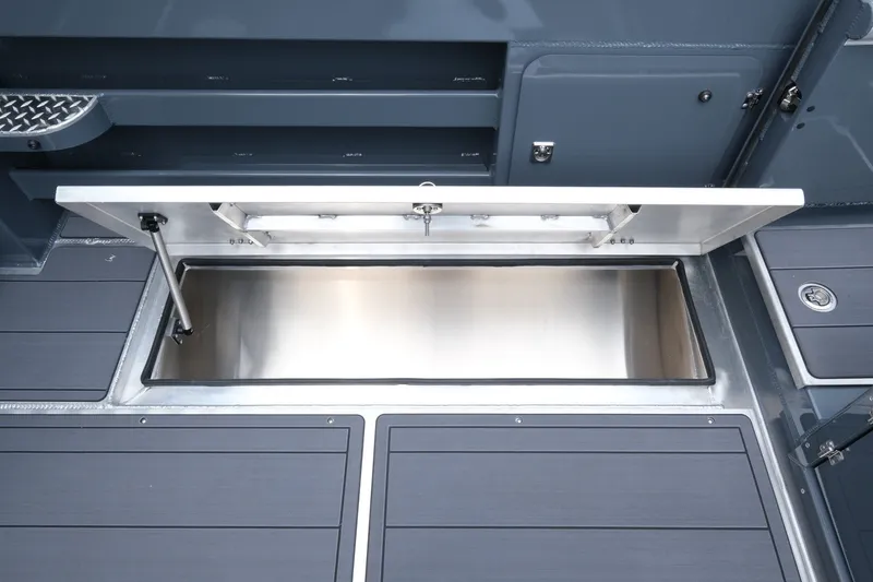 Slide: The Image of 2026 Hewescraft 250 Alaskan boat storage compartment with open hatch, showcasing sleek design. - 18
