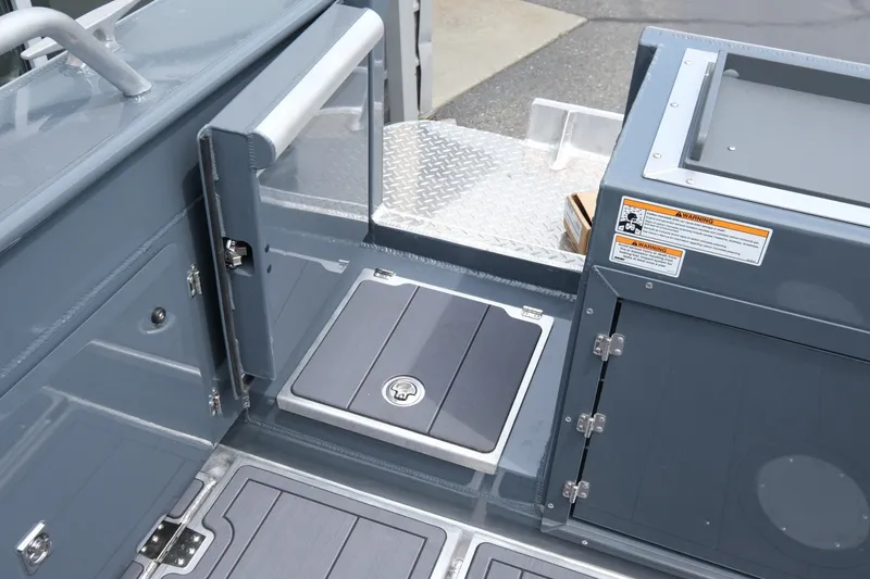 Slide: The Image of Interior view of 2026 Hewescraft 250 Alaskan boat, featuring storage compartments and safety warnings. - 20