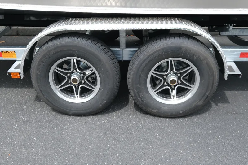Slide: The Image of Trailer wheels of a 2026 Hewescraft 250 Alaskan on asphalt surface. - 22