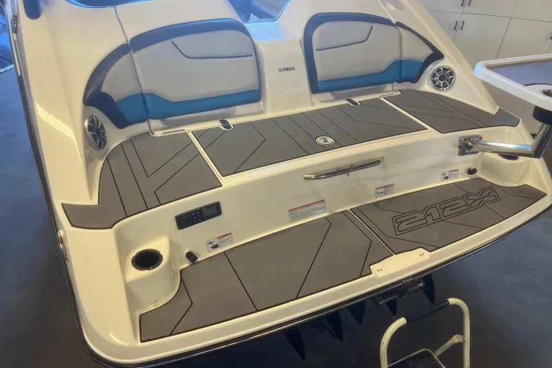 Slide: The Image of 2019 Yamaha Boats 212X rear deck with seating and speakers in a garage setting. - 4