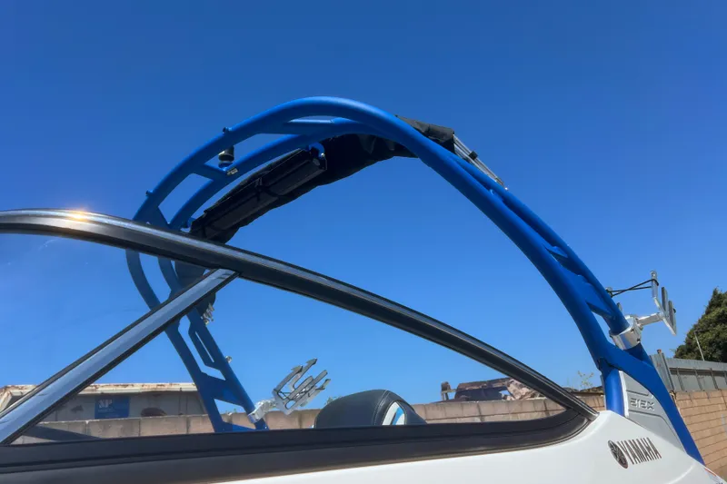 Slide: The Image of 2019 Yamaha Boats 212X with blue wakeboard tower against clear sky. - 24