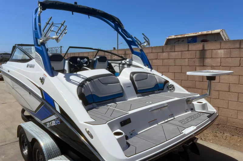 Slide: The Image of 2019 Yamaha Boats 212X with sleek design and modern features, parked outdoors. - 6