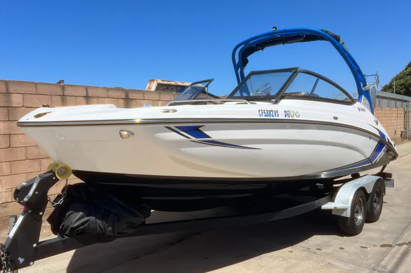 Slide: The Image of 2019 Yamaha Boats 212X on trailer, sleek design, blue accents, parked outdoors. - 3