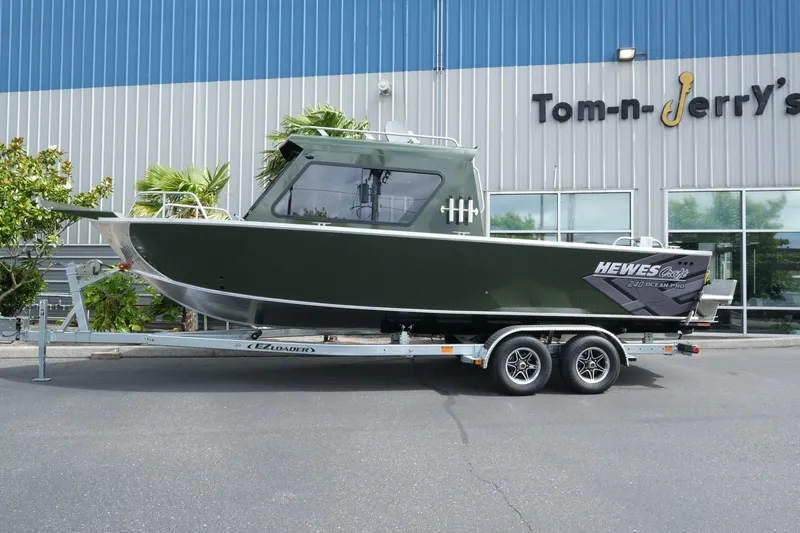 Slide: The Image of 2026 Hewescraft 240 Ocean Pro ET Hardtop boat on trailer outside dealership. - 2