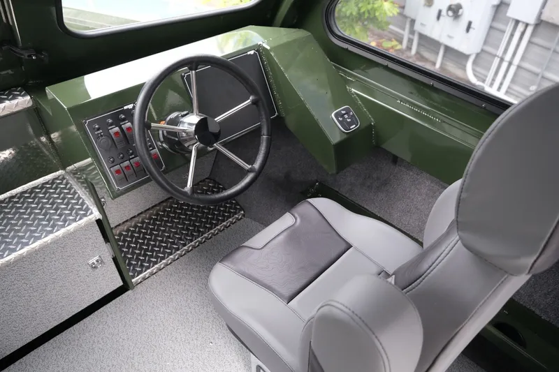 Slide: The Image of Interior of 2026 Hewescraft 240 Ocean Pro ET Hardtop, featuring steering wheel and control panel. - 12