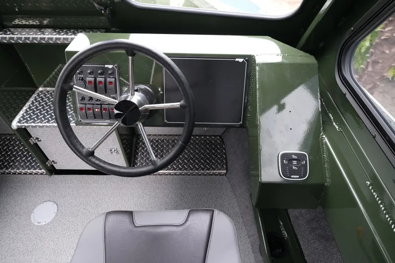 Slide: The Image of Interior of 2026 Hewescraft 240 Ocean Pro ET Hardtop, featuring steering wheel and control panel. - 13