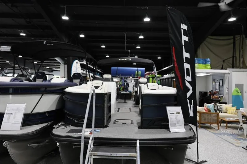 The Image of 2026 Evotti 723QL pontoon boat displayed indoors with promotional banner. - 1