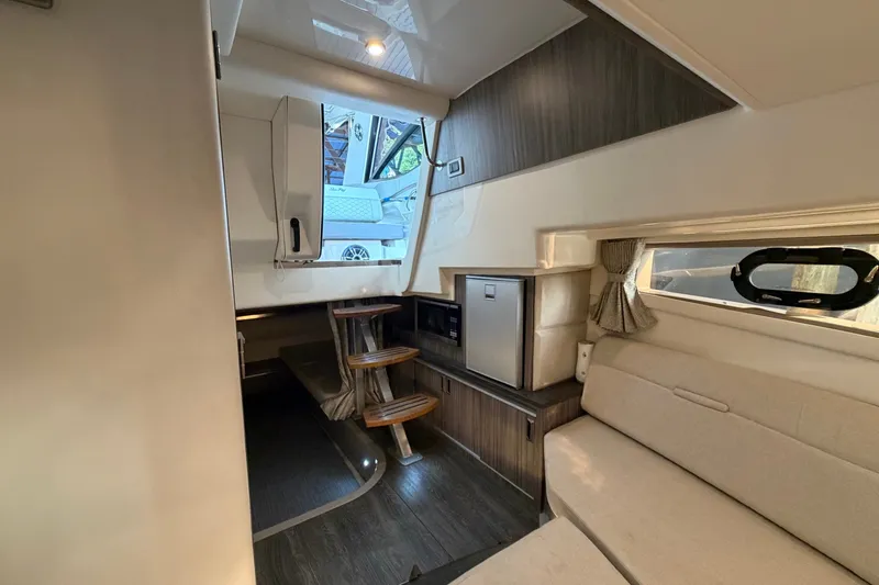 Slide: The Image of Interior of 2020 Sea Ray Sundancer 320 yacht, featuring modern seating and compact kitchenette. - 26