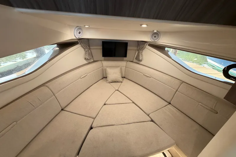 Slide: The Image of Interior of 2020 Sea Ray Sundancer 320, featuring a cozy seating area and windows. - 18