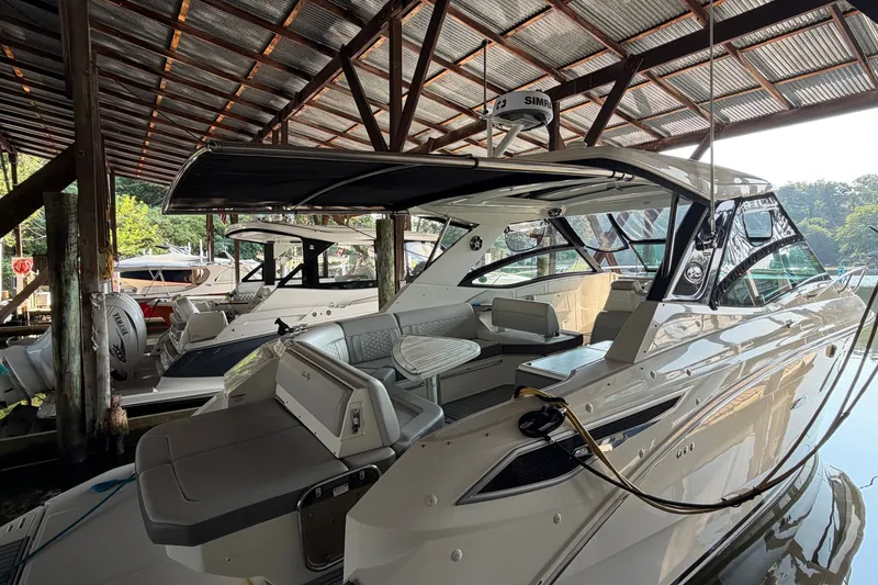 Slide: The Image of 2020 Sea Ray Sundancer 320 yacht docked under a covered marina. - 2